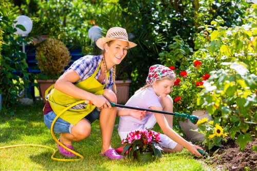 Gardeners wearing PPE and using machinery safely