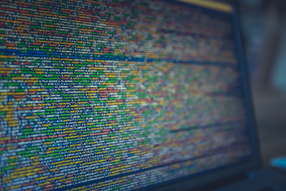 A computer screen displaying dense lines of colorful programming code, with various keywords and functions highlighted in different colors such as green, orange, yellow, and blue. The code is written